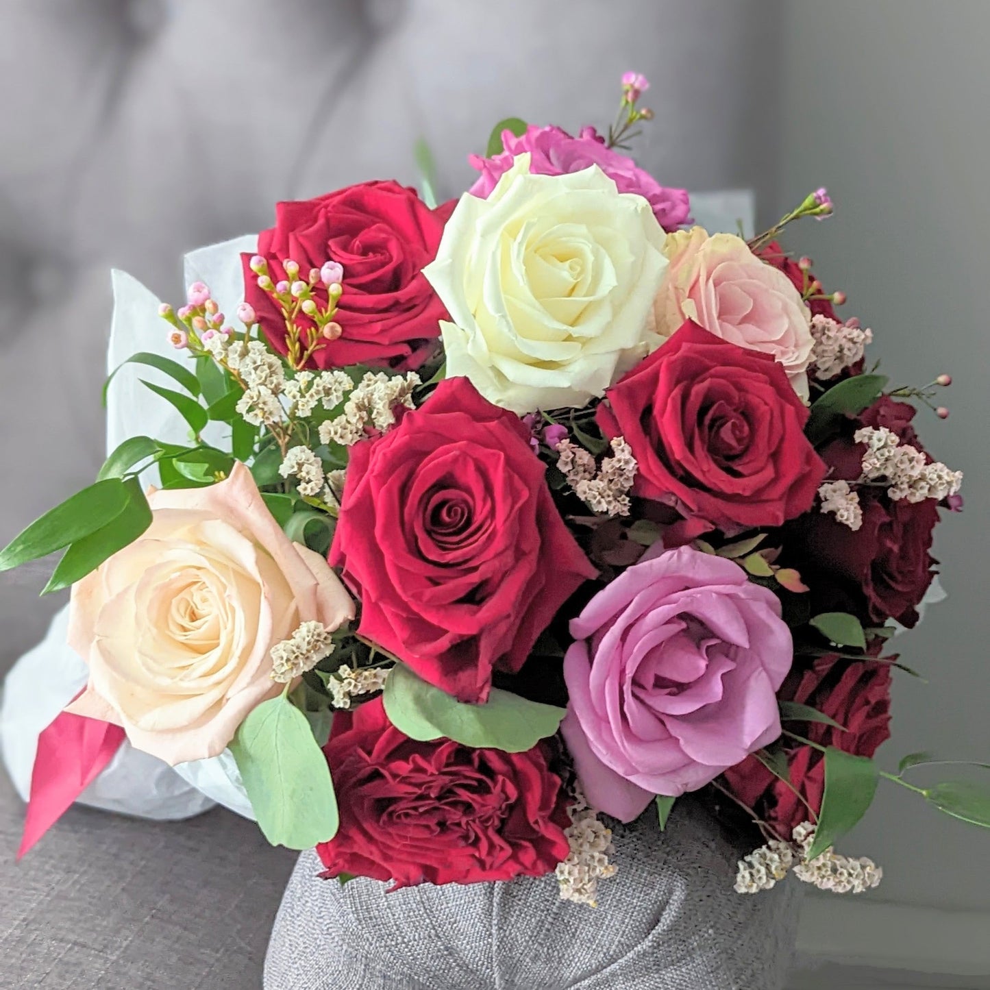 A dozen roses and filler wrapped in paper