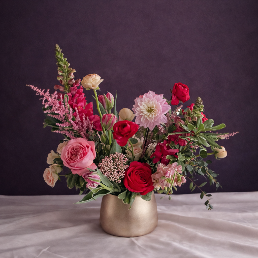 Bouquet of flowers in a silver vase on a dark background