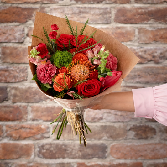 A bright bouquet in front of a brick building